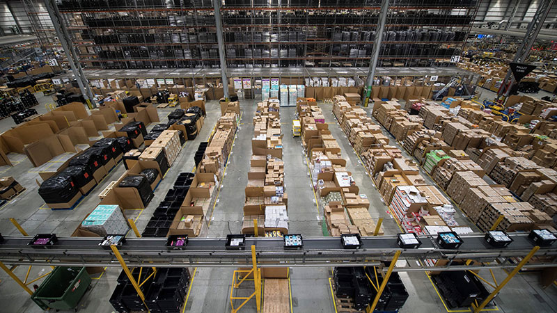 A Amazon está implantando tecnologia para manter os trabalhadores separados em seus cavernosos centros de distribuição. IMAGEM: CHRIS J RATCLIFFE/AFP/GETTY IMAGES